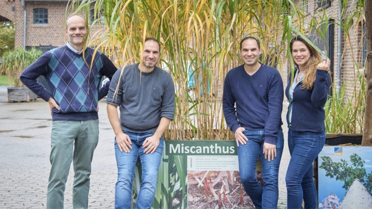Prof. Dr. Ralf Pude (links) mit Emin und Yasin Gündogmus und Rümeysa Saemian in Klein-Altendorf. Im Hintergrund Miscanthus, ein nachwachsender Rohstoff.