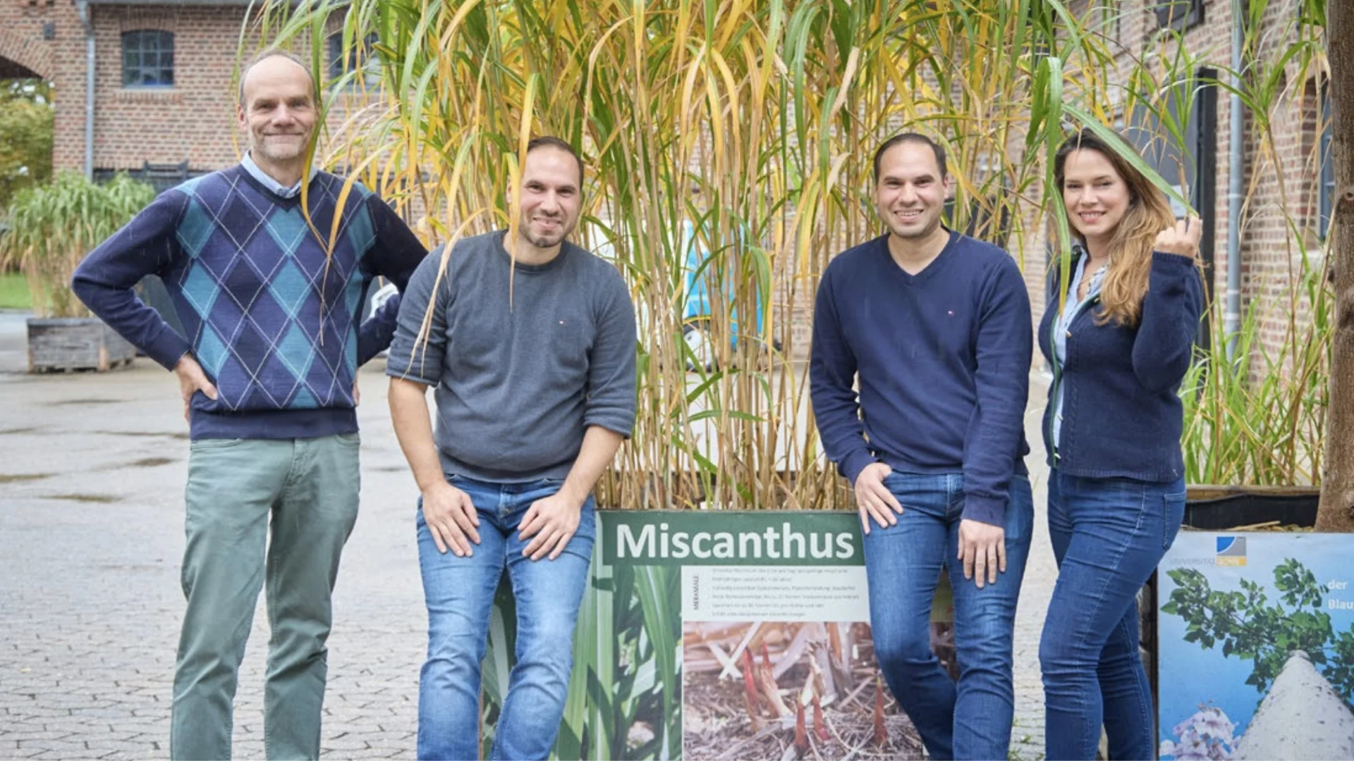 Prof. Dr. Ralf Pude (links) mit Emin und Yasin Gündogmus und Rümeysa Saemian in Klein-Altendorf. Im Hintergrund Miscanthus, ein nachwachsender Rohstoff.
